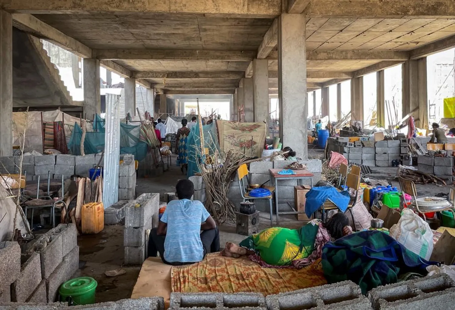 People displaced by the recent conflict live in crowded conditions at a makeshift camp for the displaced in a derelict building of the Shire campus of Axum University, in Shire, in the Tigray region of northern Ethiopia Tuesday, Feb. 23, 2021. (International Rescue Committee via AP)