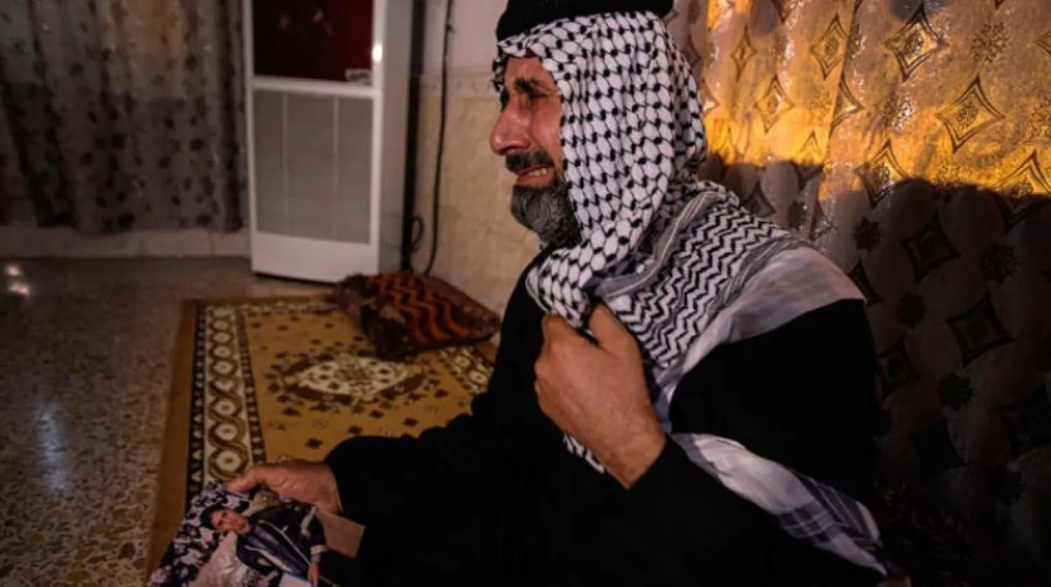 Casib el Hecli, el Amara’daki evinde kaçırılan oğlunun fotoğrafını tutarken (AP)