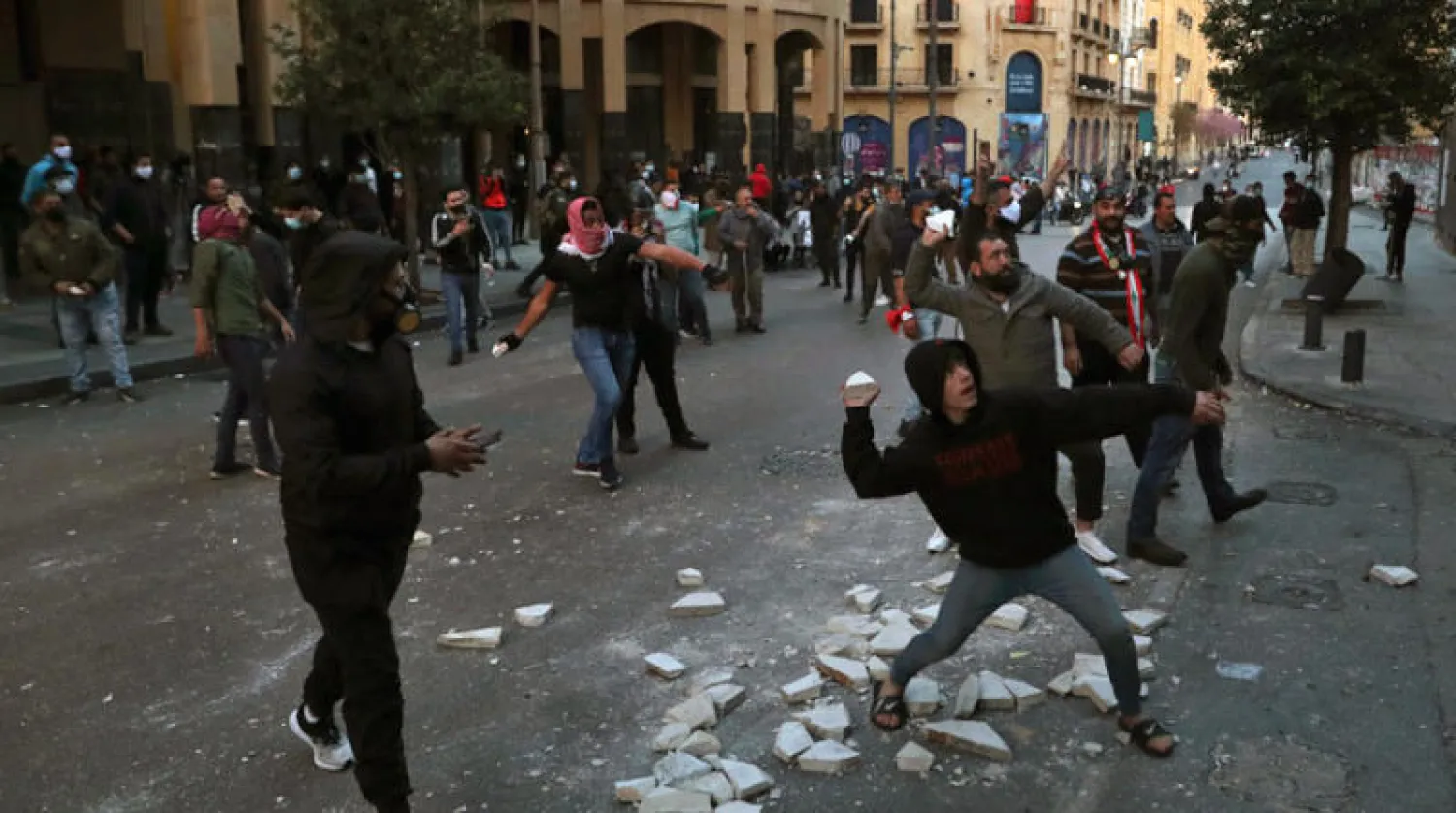 محتجون يرشقون قوات الأمن بالحجارة خلال مواجهات وسط بيروت أمس (أ.ب)