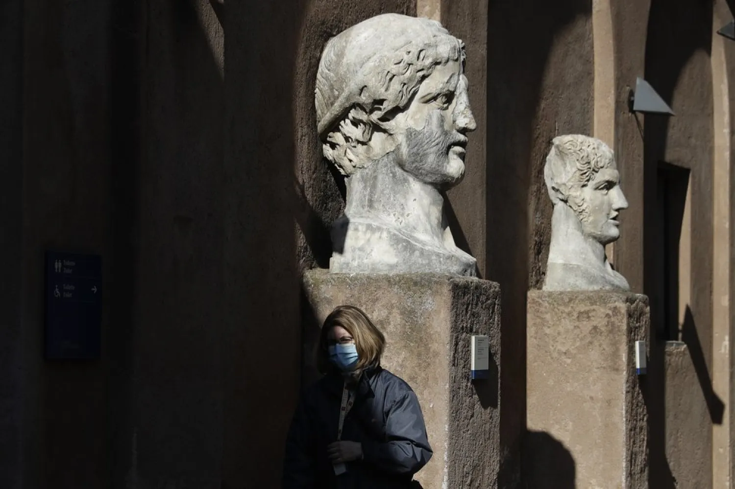 A museum usher stands by marble busts at the entrance of the Sant'Angelo castle In Rome Tuesday, March 2, 2021.  (AP Photo/Gregorio Borgia)
