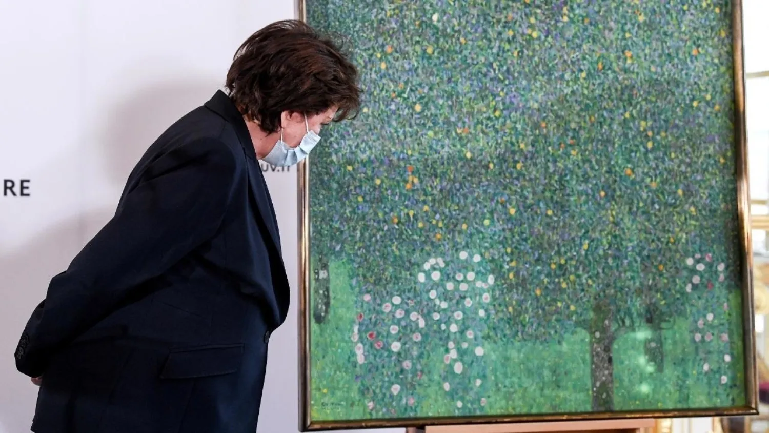 French Culture Minister Roselyne Bachelot stands next to the painting "Rosebushes under the Trees" by Austrian painter Gustav Klimt, at the Musee d'Orsay in Paris, France March 15, 2021. (Reuters)