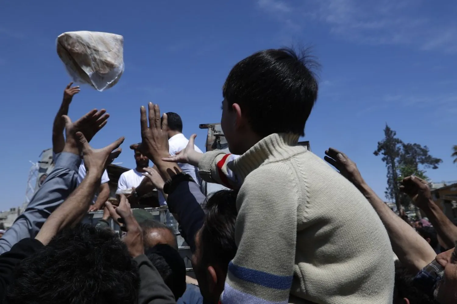In this April 16, 2018 file photo, Syrian authorities distribute bread, vegetables and pasta to residents in the town of Douma, near Damascus, Syria. (AP)