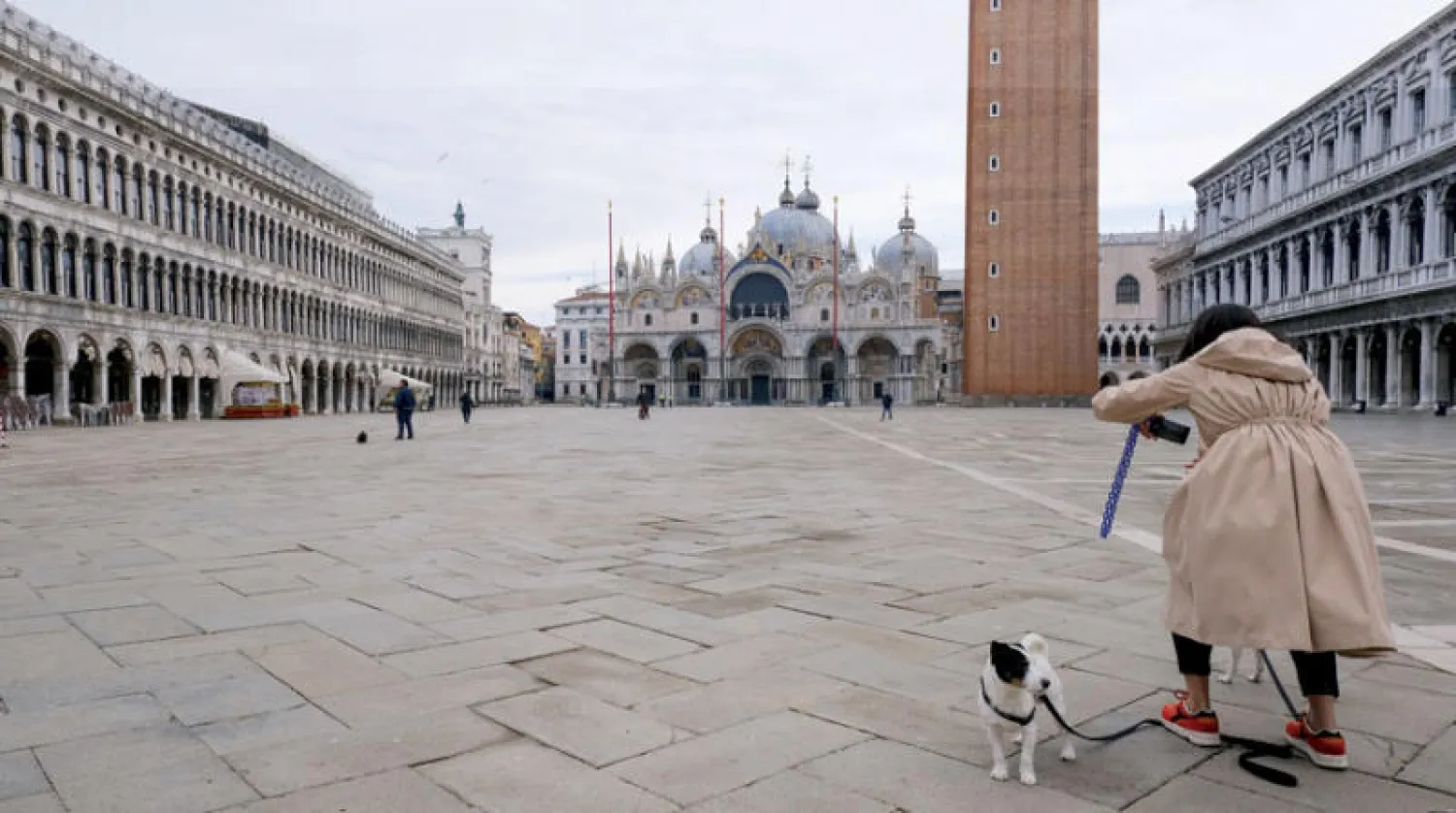 امرأة تلتقط صوراً في ساحة «القديس مارك» في البندقية (رويترز)
