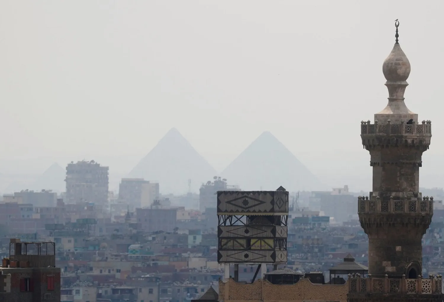 A view of Old Cairo with a mosque minaret and the Great Pyramids in Cairo, Egypt March 21, 2020. (Reuters)
