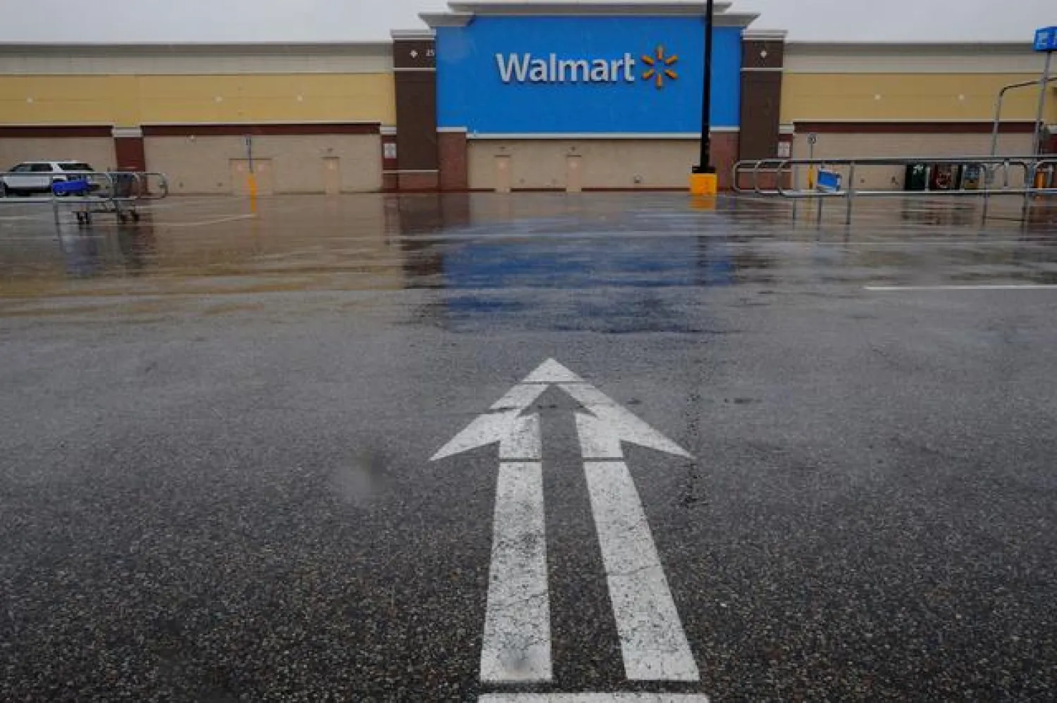 FILE PHOTO: An arrow in the parking lot points to a Walmart Superstore, temporarily closed by an order from the city after numerous employees tested positive for the coronavirus, which causes COVID-19, in Worcester, Massachusetts, U.S., April 30, 2020. REUTERS/Brian Snyder/File Photo