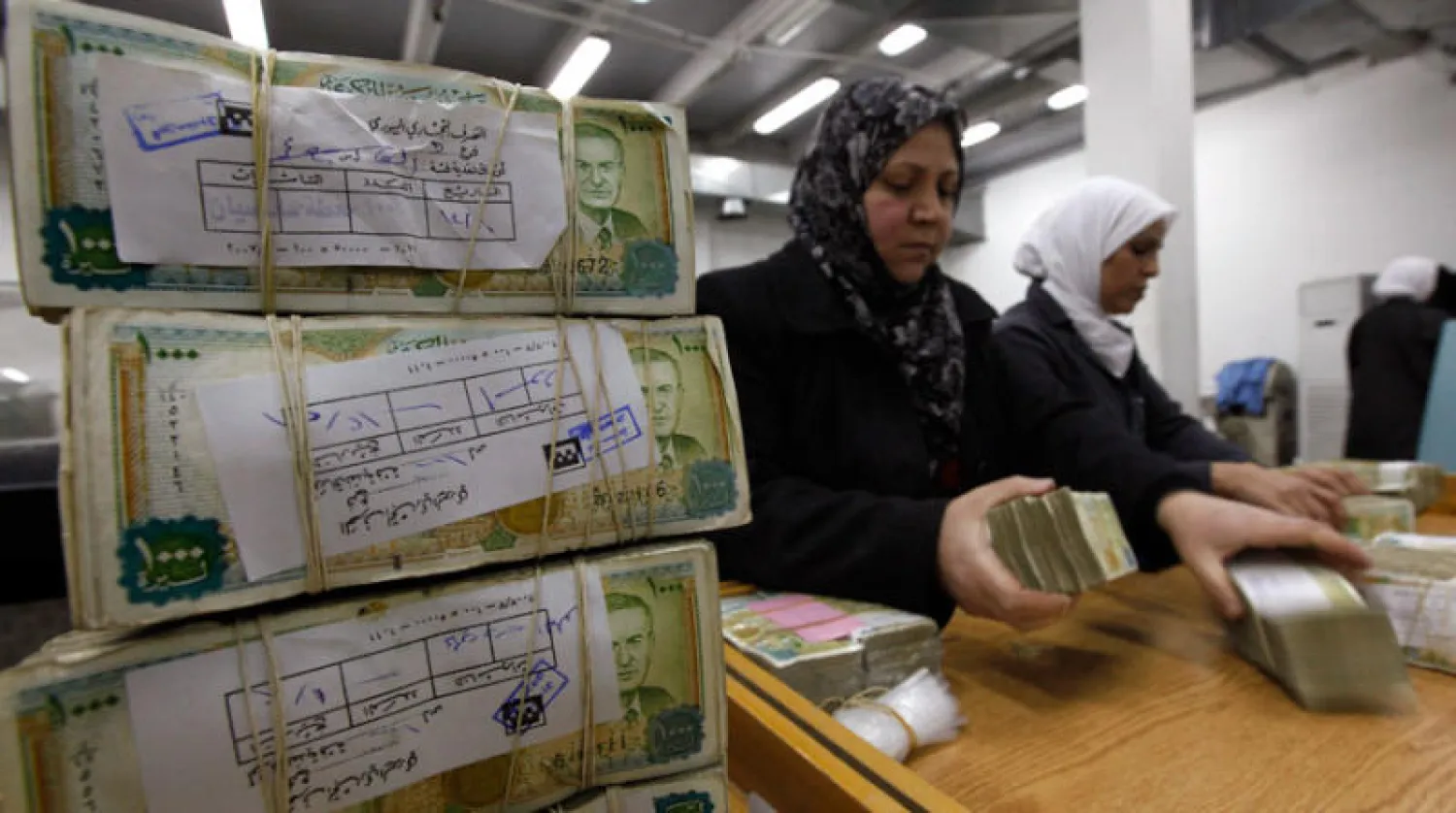 سيدتان تعدّان أوراقاً نقدية في المصرف السوري المركزي في 13 يناير 2012 (أ.ب)