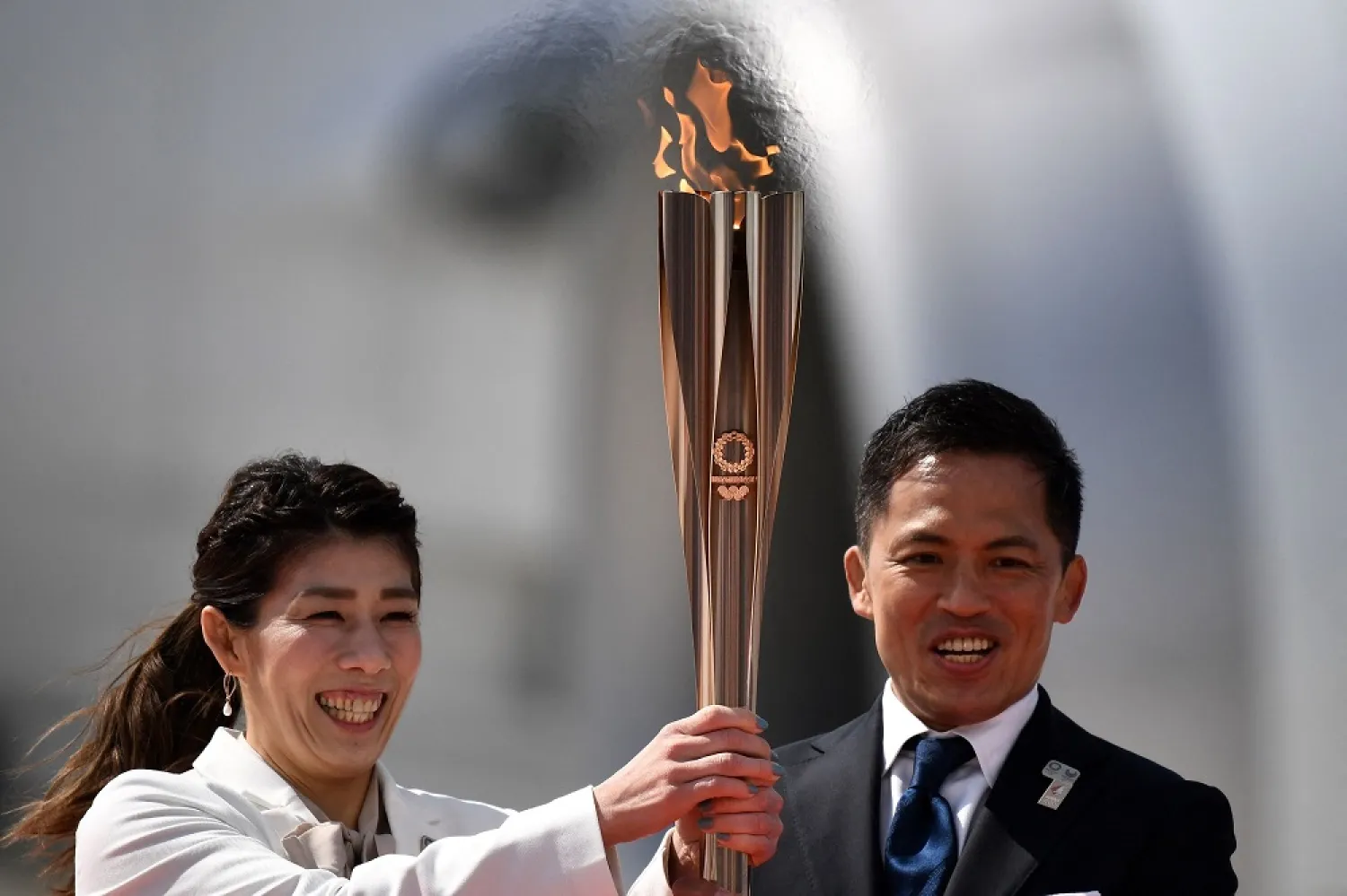 Japanese three-time Olympic gold medalists Saori Yoshida (L) and Tadahiro Nomura (R) hold the Tokyo 2020 Olympic Torch, Higashimatsushima, Japan, March 20, 2020. (AFP)