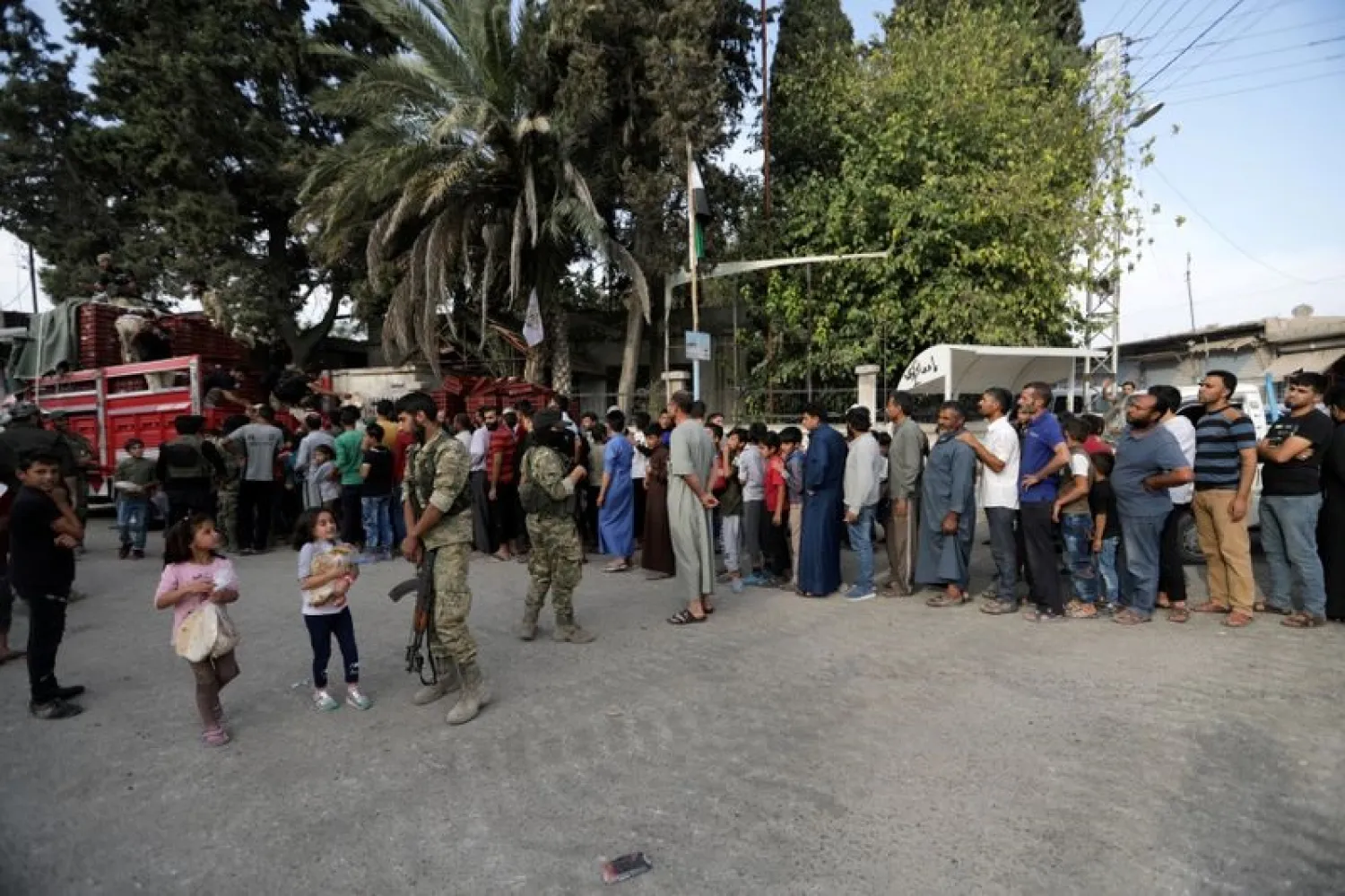 People stand in a queue to get bread in the border town of Tal Abyad, Syria, October 15, 2019. (Reuters)