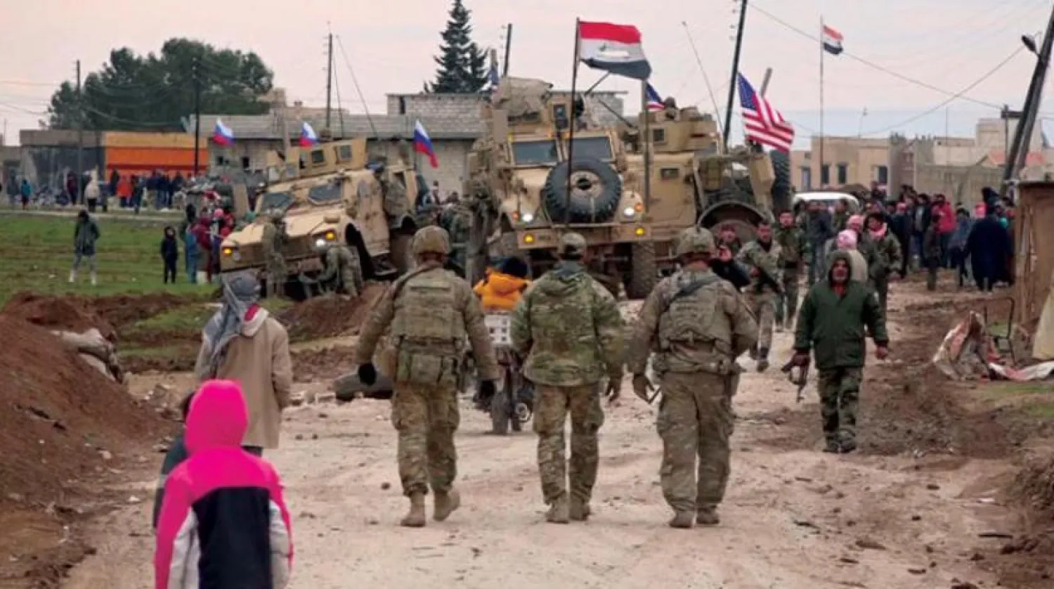 12 Şubat 2020’de, Fırat’ın doğusundaki Kamışlı yakınlarındaki ABD, Rusya ve Suriye ordularına ait bayraklar ve araçlar. (AP)