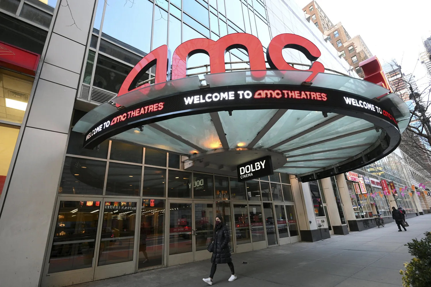 A pedestrian walks by an AMC theater in New York. AP