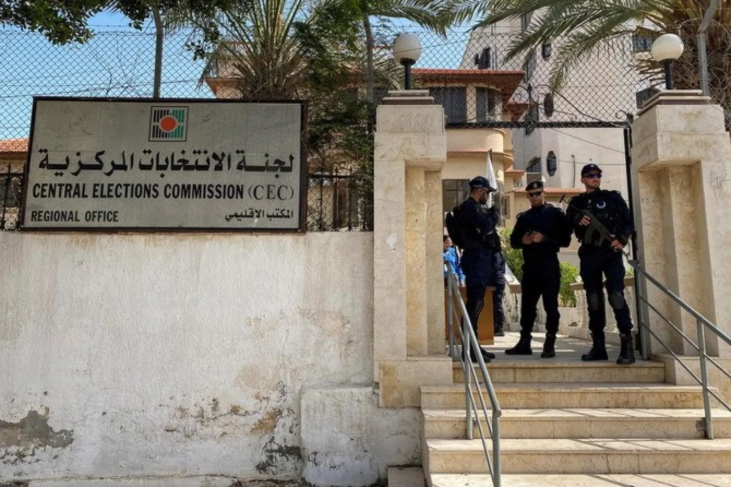 Police officers stand guard as Palestinians begin registering party lists for May parliamentary election, at the Central Elections Commission's office in Gaza City March 20, 2021. (Reuters)
