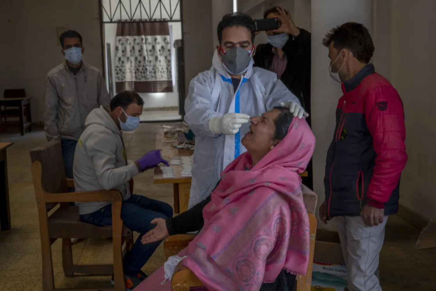 إجراء فحص كشف فيروس كورونا لسيدة في مدينة سريناغار في الشطر الهندي من كشمير (أ.ب)