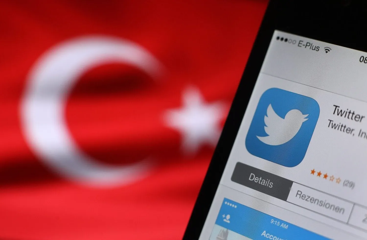 The Twitter logo seen on a smartphone held beside a Turkish flag. (EPA)
