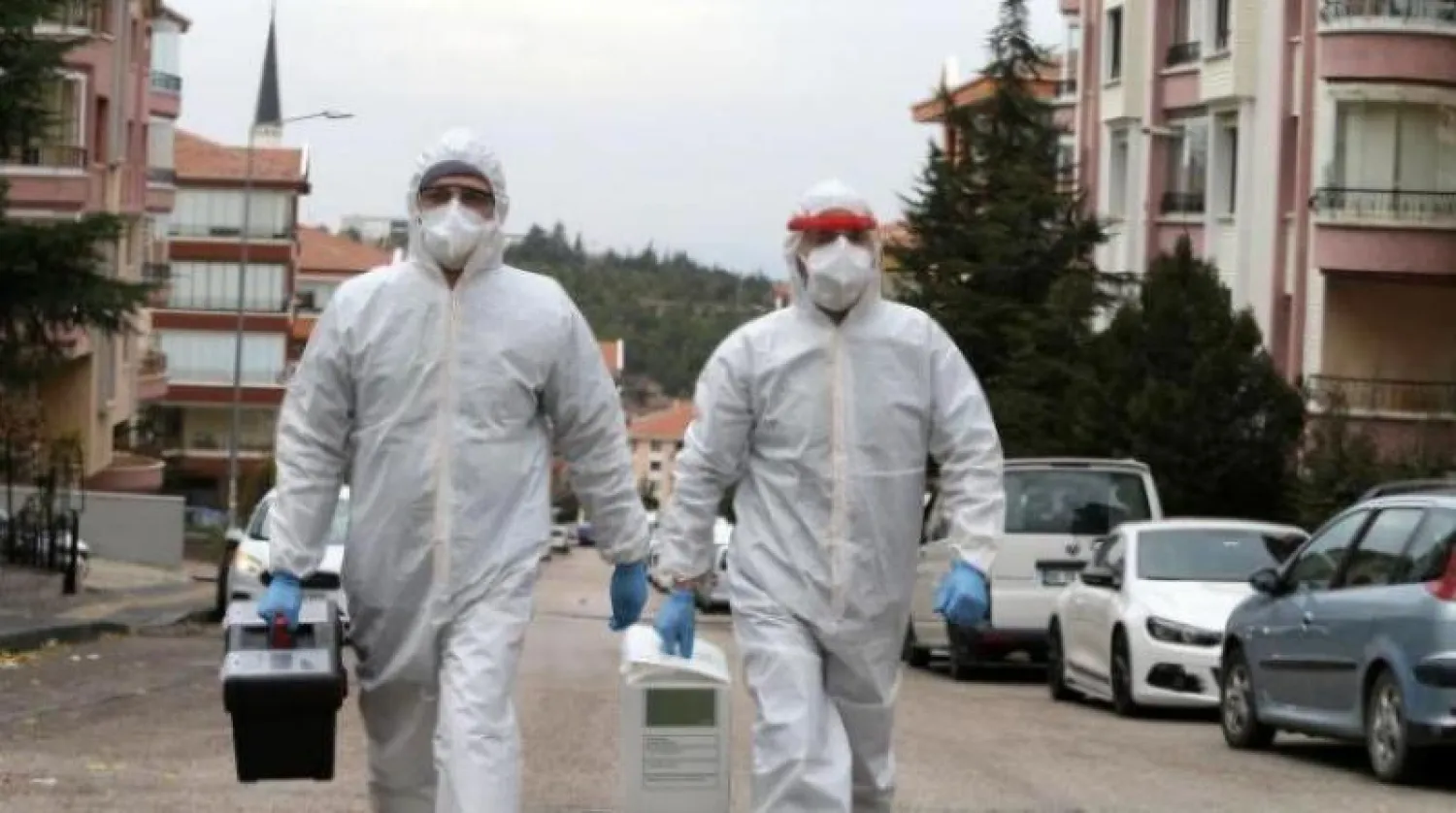 عاملا رعاية صحية يرتديان ملابس واقية في طريقهما إلى مصاب بـ«كورونا» في أنقرة (أ.ف.ب)
