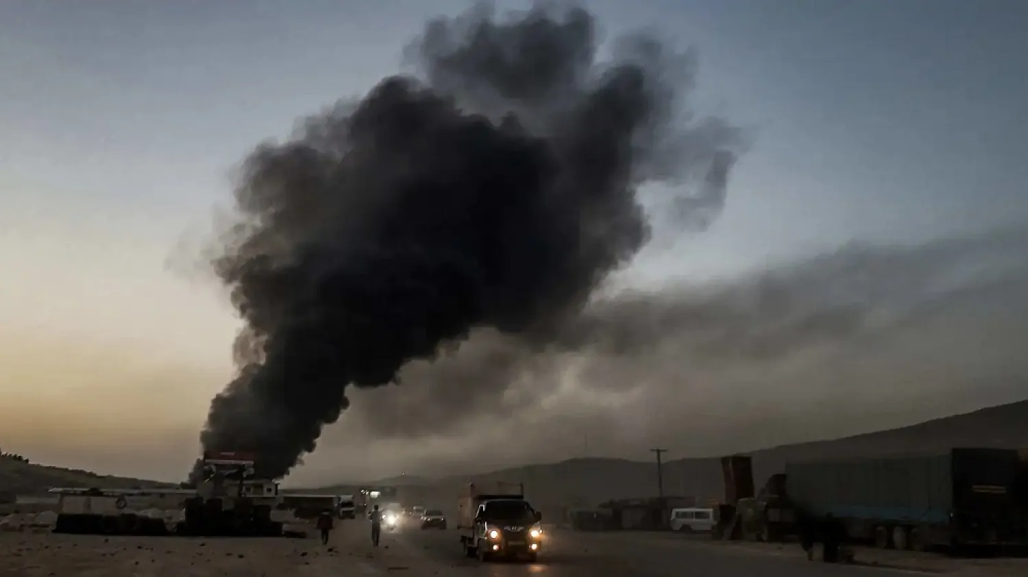 This picture taken on March 21, 2021, shows a billowing smoke plume coming from burning vehicles in the aftermath of airstrikes near the Bab al-Hawa border-crossing between Syria and Turkey in Syria's Idlib province. (AFP)