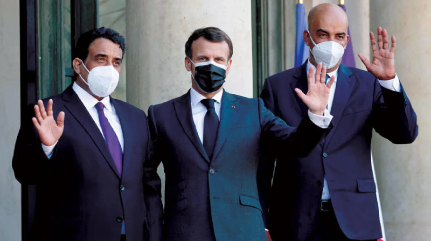 ماكرون يتوسط المنفي (يسار) والكوني خلال زيارتهما إلى باريس أمس (أ.ف.ب)