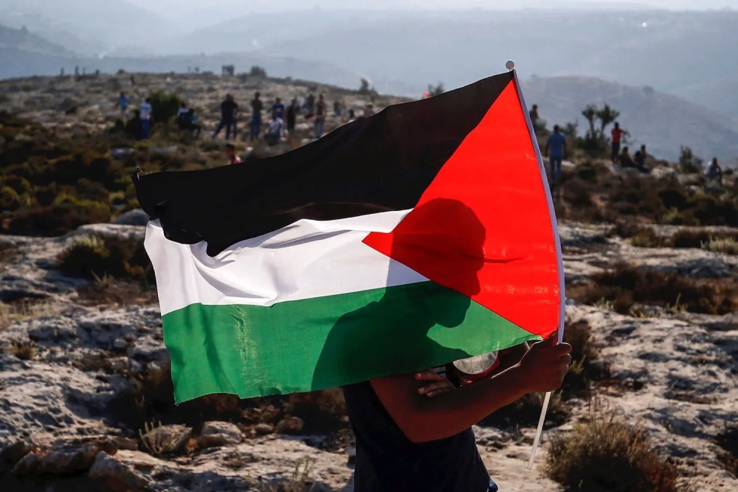 A Palestinian protester waves a Palestinian flag during a demonstration in the village of Ras Karkar in the occupied West Bank, on Sept. 4, 2018. (Getty Images)
