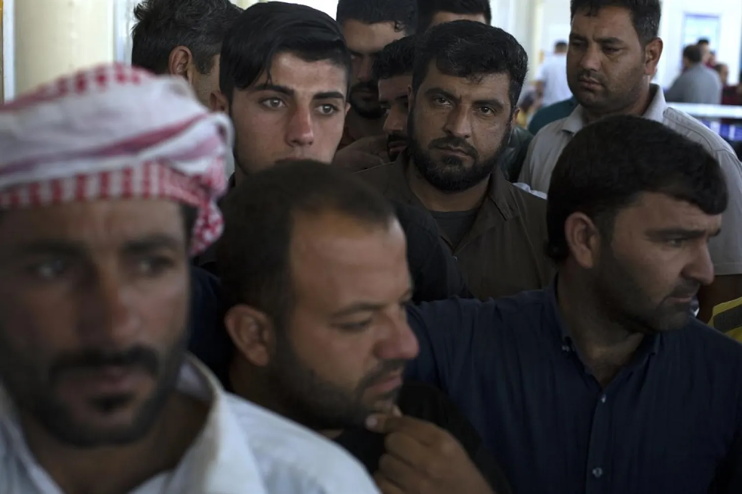 Displaced men from Mosul wait in a queue before casting their ballot in the parliamentary elections at a polling site in a camp for displaced people in Baharka, Iraq, Saturday, May 12, 2018. (AP)