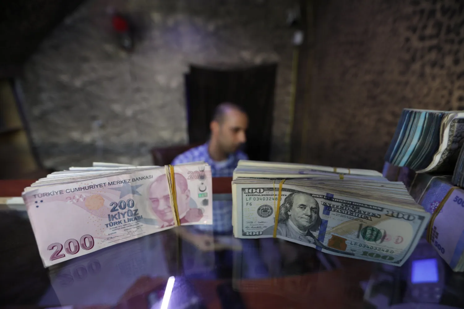 FILE PHOTO: Banknotes of US dollars and Turkish lira are seen in a currency exchange shop in Azaz, Syria, August 18, 2018. REUTERS/Khalil Ashawi