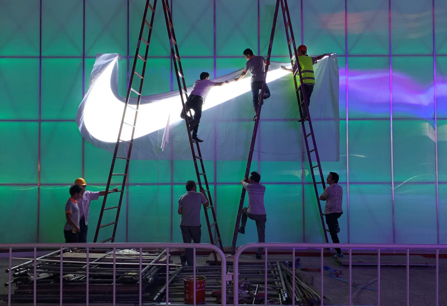 FILE PHOTO: Workers install a Nike logo lamp outside the Wukesong Arena in Beijing, China August 28, 2019. REUTERS/Tingshu Wang