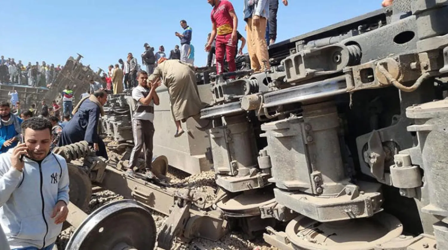 مصريون يعاينون حطام قطارين تصادما في محافظة سوهاج أمس (أ.ف.ب)