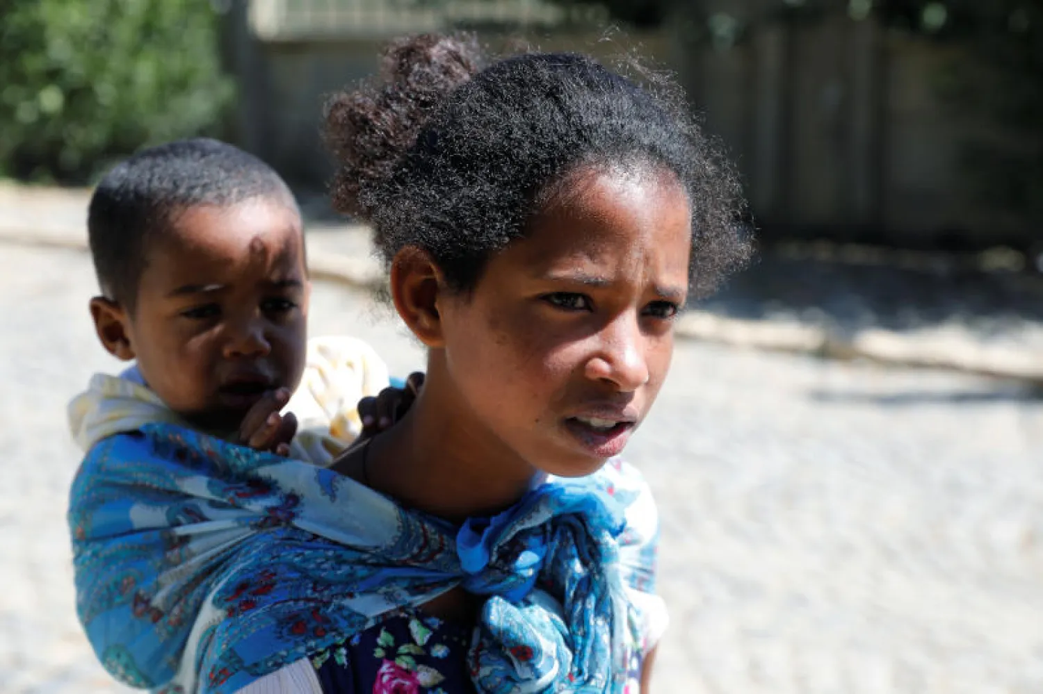 ميبراك إسايوس تحمل أحد أشقائها (رويترز)