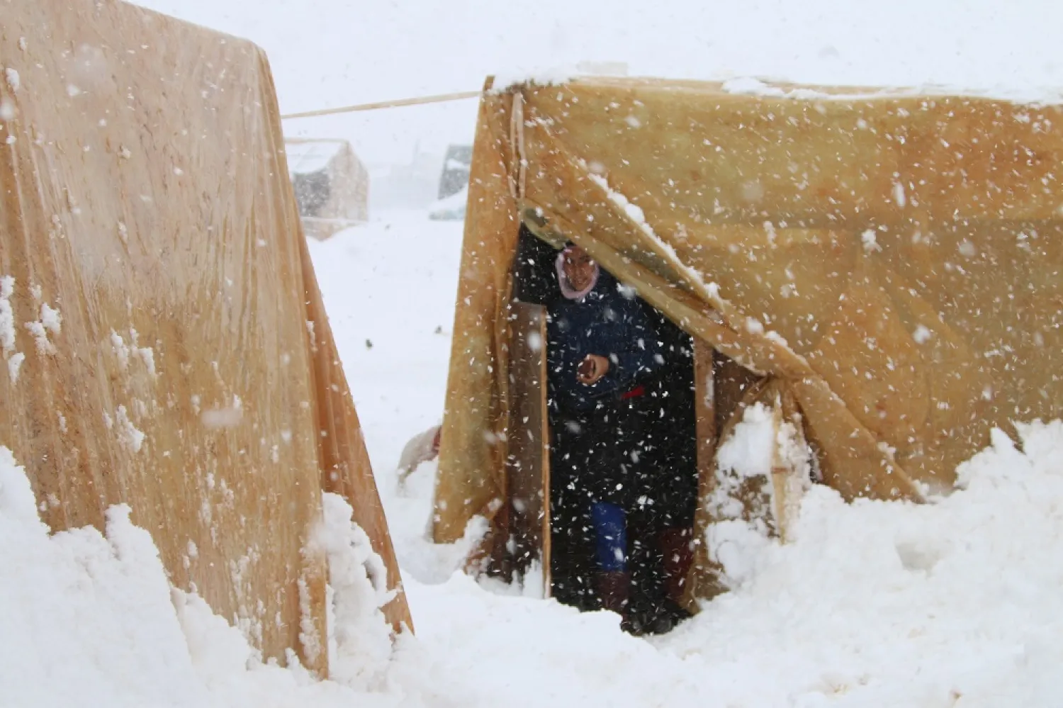A Syrian refugee stands at the entrance of her tent during a snow storm at an unofficial camp on the road between Riyaq and Baalbek in Lebanon's eastern Bekaa Valley. (AFP file photo)