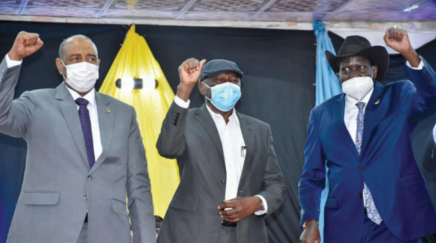 البرهان وسلفاكير يتوسطهما الحلو بعد توقيع إعلان المبادئ في جوبا أمس (رويترز)