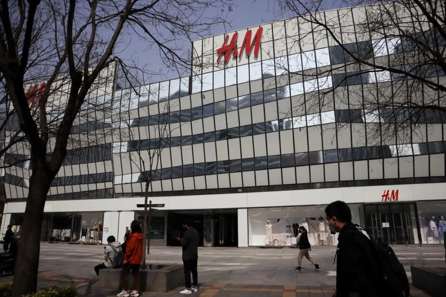 FILE PHOTO: People walk past a store of the Swedish fashion retailer H&M at a shopping complex in Beijing, China March 25, 2021. REUTERS/Florence Lo/File Photo