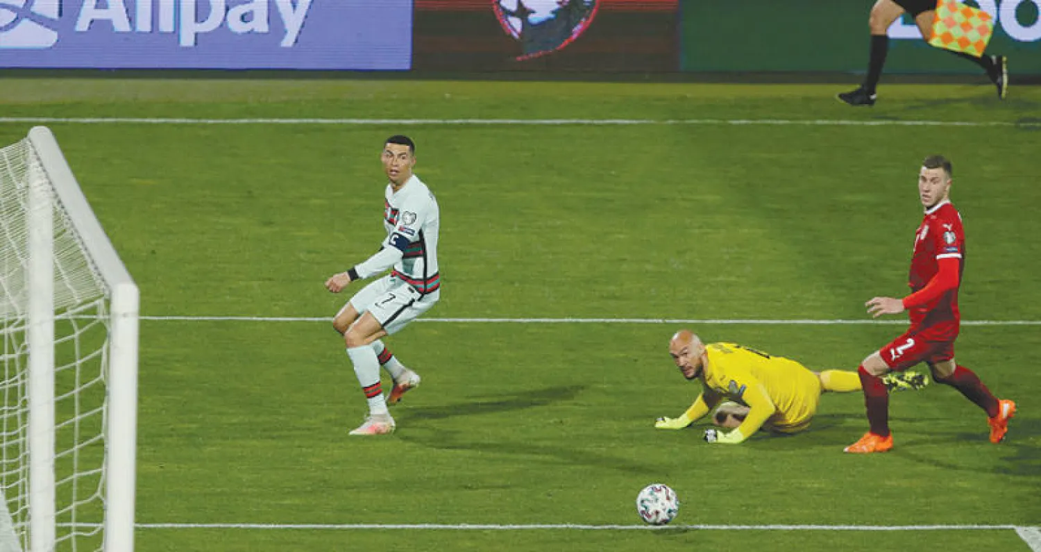 رونالدو نجم البرتغال وقائدها (يسار) يراقب تسديدته وهي في طريقها لمرمى صربيا (غيتي)