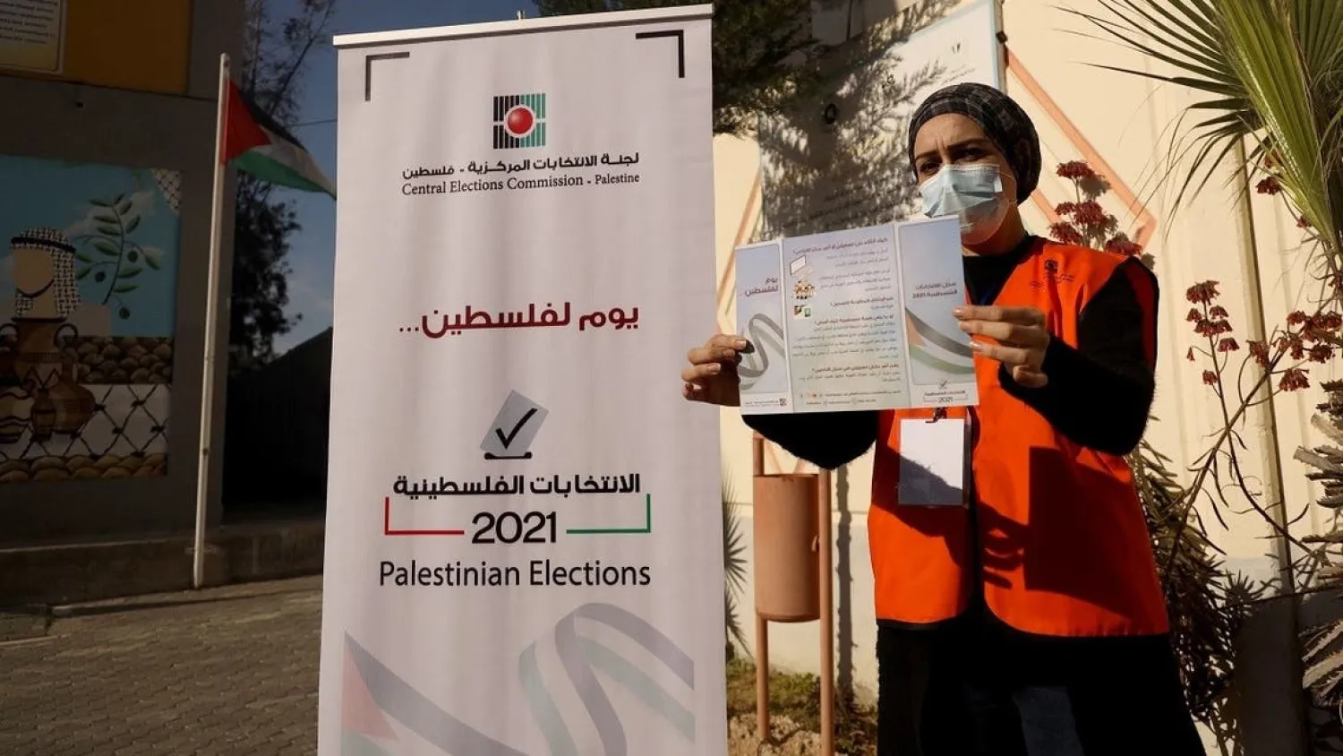 Palestinian member of the Central Elections Commission displays an information leaflet on elections (File photo: AFP)
