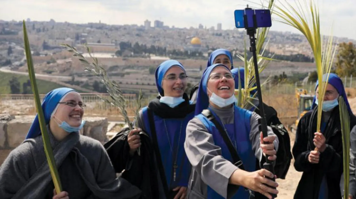 Filistinli rahibeler Kudüs’e tepeden bakan Zeytin Dağı’nda selfie çekiyor (AP)