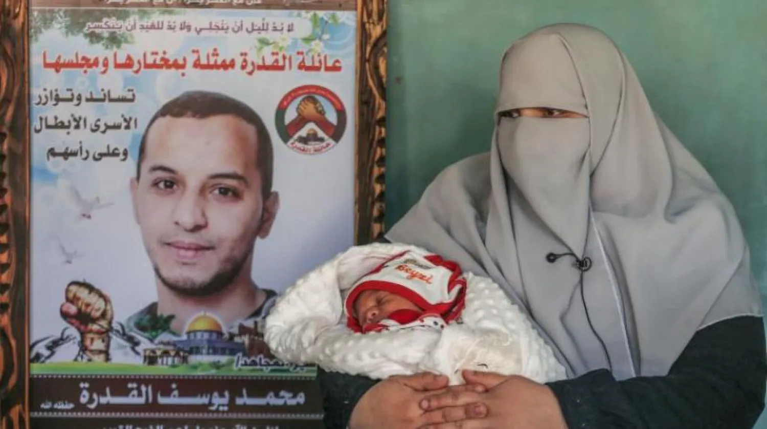 İman Kudra kucağında bebeği Mücahid’i tutuyor (AFP)