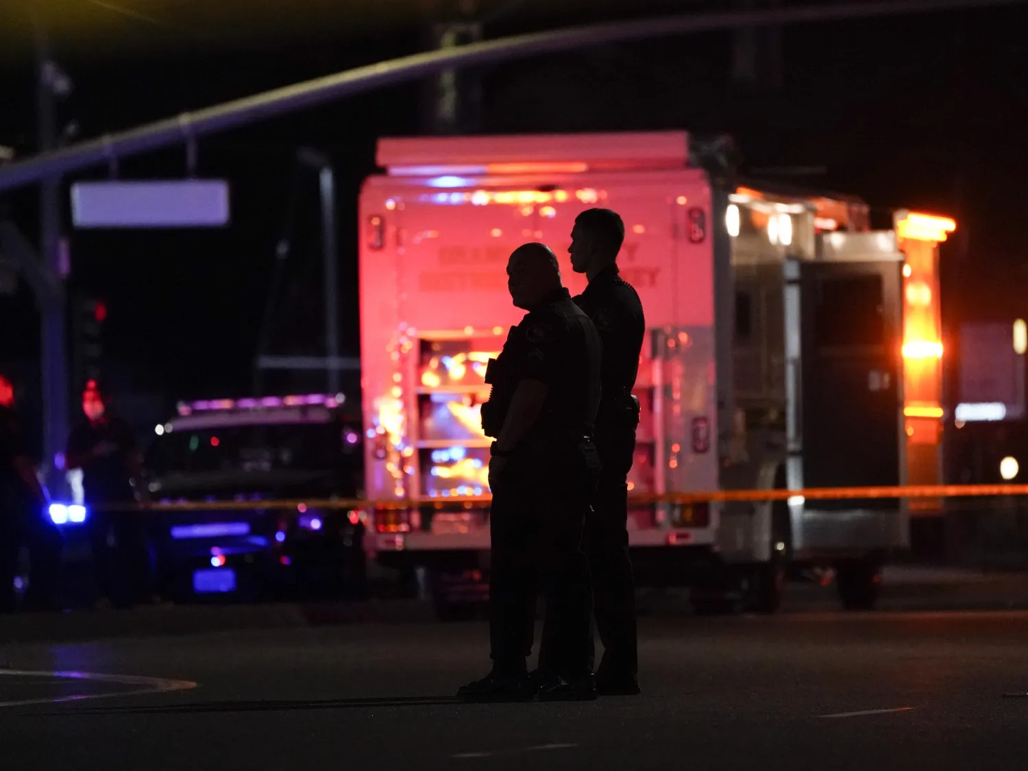 Two police officers stand outside an office building where a shooting occurred in Orange, Calif., Wednesday, March 31, 2021. AP