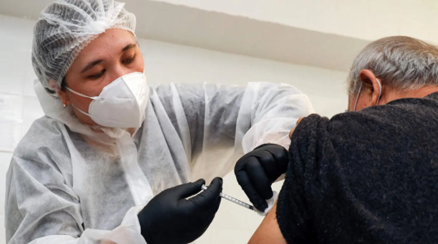 مسن يتلقى لقاح «أسترازينيكا» في أوزباكستان أمس (أ.ف.ب)
