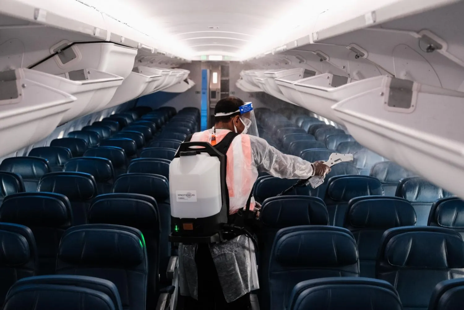 A worker sprays disinfectant inside a Delta airplane at the
Ronald Reagan Washington National Airport in Arlington, Virginia,
between flights to kill any coronavirus left on surfaces.  Getty
Images/AFP