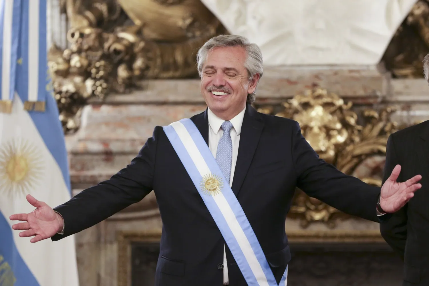 Argentina's President Alberto Fernandez opens his arms at the presidential palace in Buenos Aires, Argentina, Tuesday, Dec. 10, 2019. (AP Photo/Daniel Jayo)
