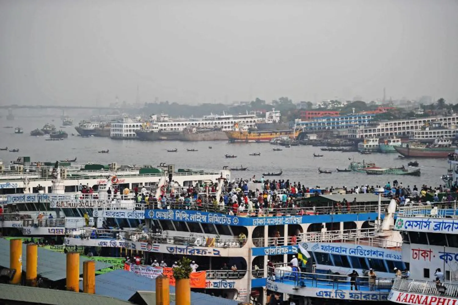 أشخاص يتكدسون على متن عبارات في دكا للسفر إلى بلادهم مع عزم الحكومة فرض قيود جديدة لاحتواء كورونا (أ.ف.ب)