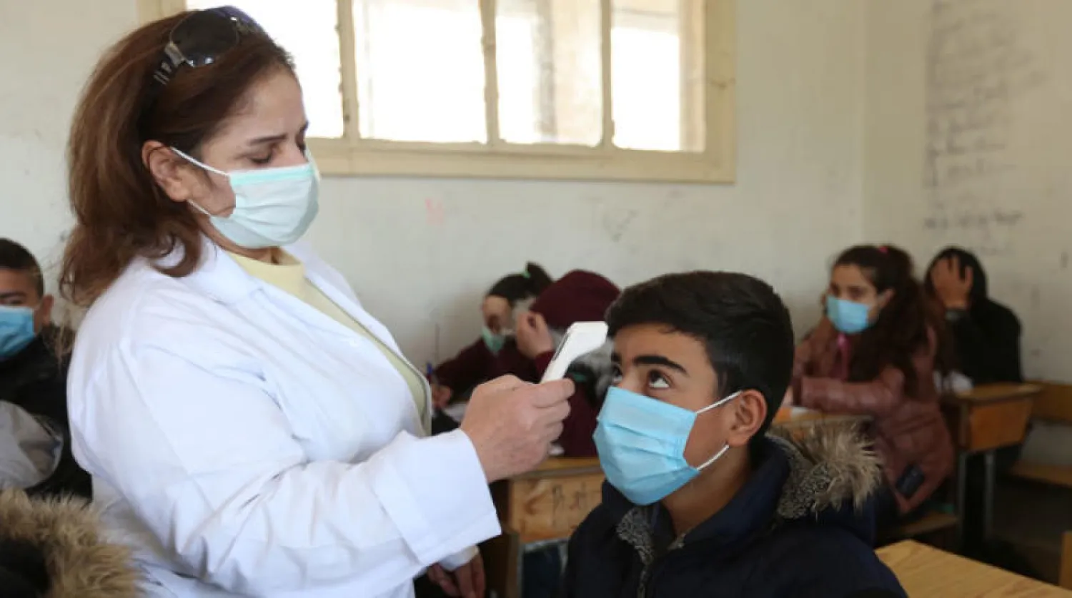 قياس حرارة طالب في إحدى مدارس دمشق (إ.ب.أ)