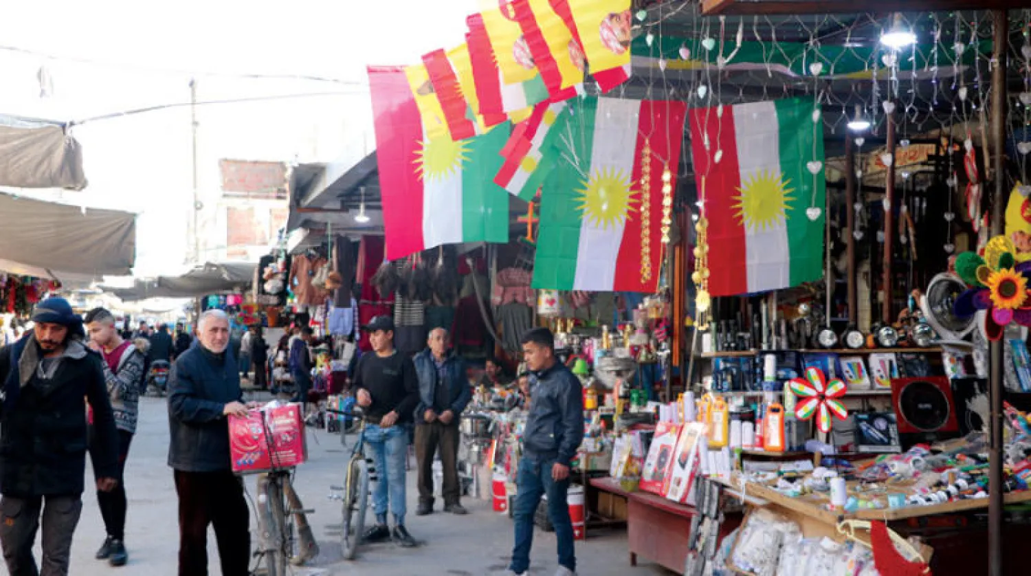 سوق القامشلي المركزي وتظهر الأعلام الكردية (الشرق الأوسط)
