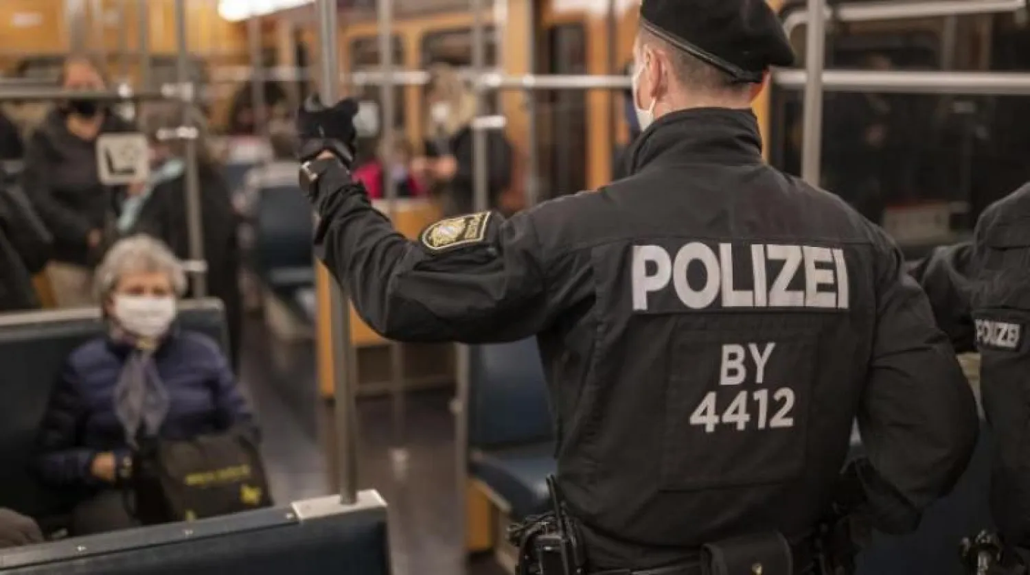 شرطي ألماني يراقب التزام ركاب المترو بوضع الكمامات في مدينة نورمبرغ (أ.ب)