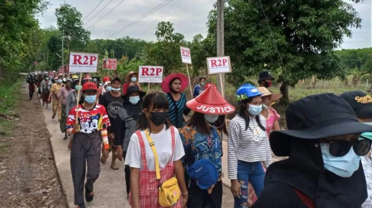 Pagado şehrindeki göstericiler uluslararası topluma Myanmarlıları koruma çağrısında bulunan pankartları taşıyor (AFP)
