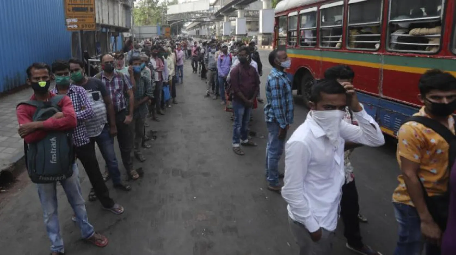 Maskeli insanlar Mumbai otobüs durağında kuyrukta (AP) 
