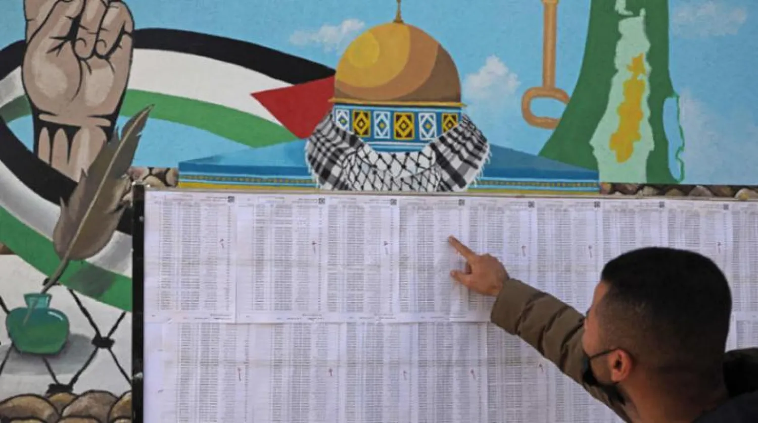 Gazzeli bir genç seçim merkezinde asılan seçmen kayıtlarında adını arıyor (AFP)