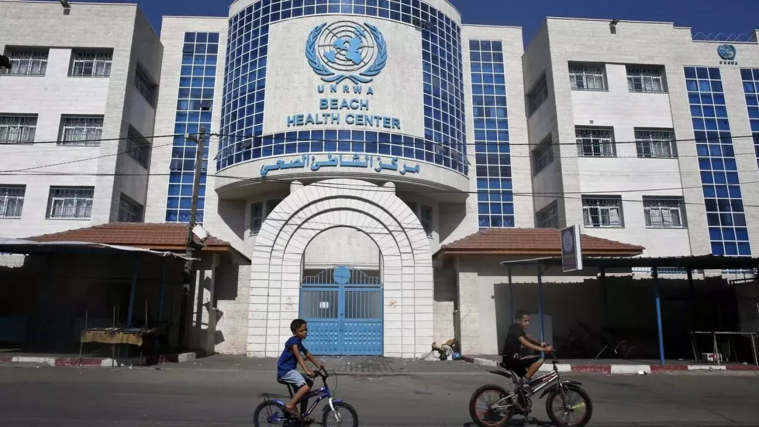 Children ride their bicycles in front of a health center run by the United Nations Relief and Works Agency (UNRWA) in Gaza (AFP)