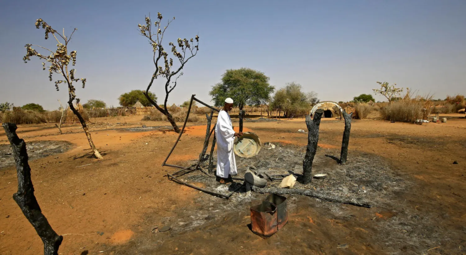 After years of conflict, clashes still erupt in the Darfur region; a man checks the aftermath of violence in the village of Twail Saadoun, the capital of South Darfur, in February 2021 ASHRAF SHAZLY AFP/File
