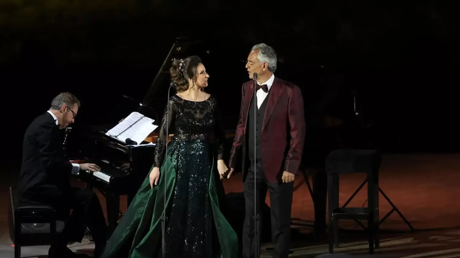 Italian tenor and opera singer Andrea Bocelli and Francesca Maionchi perform during a concert at the Hegra World Heritage Site in the northwestern Saudi city of AlUla on April 8, 2021. (AFP)