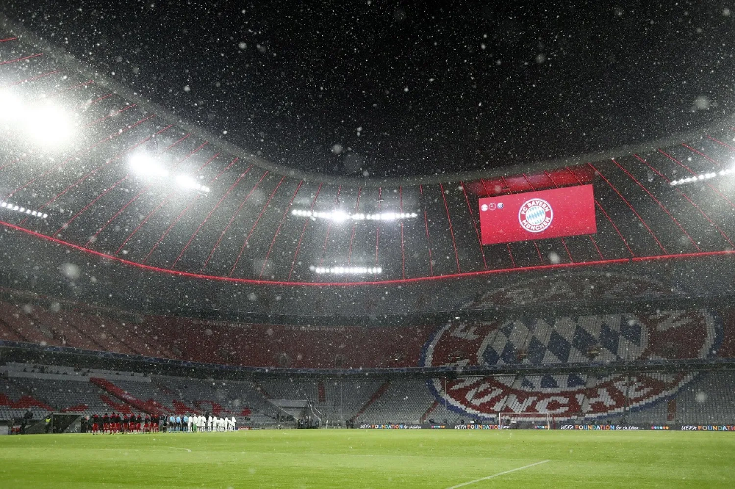 Snow falls over the stadium before the Champions League quarterfinal match between Bayern Munich and Paris Saint Germain in Munich, Germany, Wednesday, April 7, 2021. (AP)