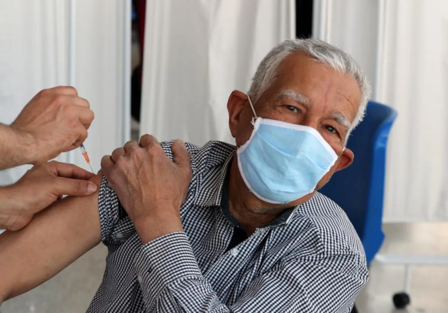 رجل يتلقى جرعة من لقاح «كورونا» في تونس (إ.ب.أ)