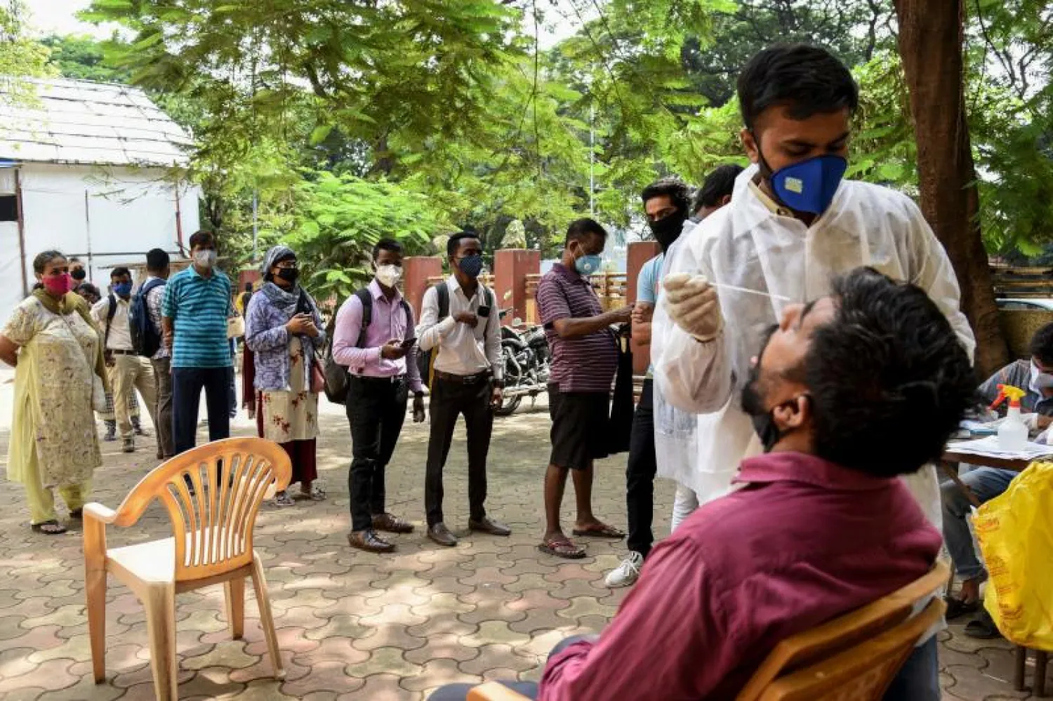 أشخاص ينتظرون لإجراء اختبار فيروس «كورونا» في مومباي (أ.ف.ب)